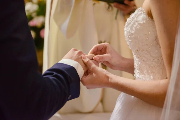 Невеста и жених во время свадебной церемонии надели обручальные кольца на пальцы — стоковое фото