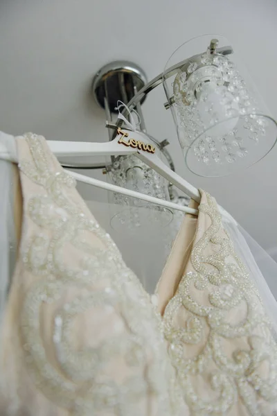 Družička pomáhá štíhlé nevěstě tkanice její svatební bílé šaty, zapínání na jemný krajkový vzor s nadýchanou sukní v pase. Ranní svatební příprava detaily novomanželé. Svatební chvíle, opotřebení. — Stock fotografie