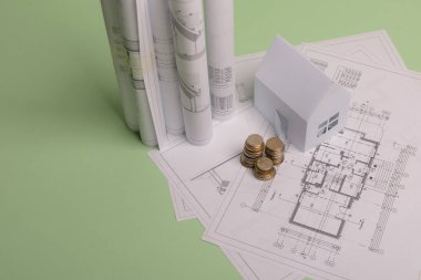 Beyaz aile kağıt evi, yığınla para, ev projeleri planı ve nane arkaplan kağıdının planları. Minimalist ve basit bir kavram, tarz. Dikey yönelim.