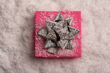 Noel hediyeleri güzel süslenmiş fiyonklar ve kardaki tüylerle. Yukarıdan görünüm.