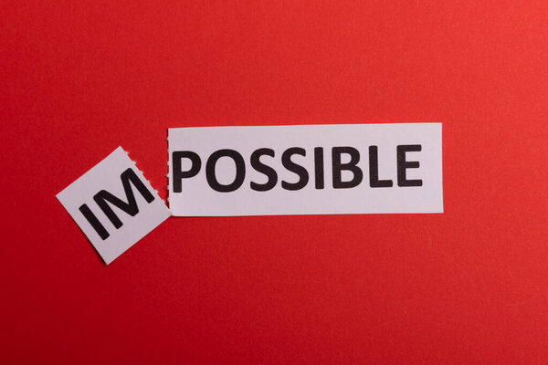 Impossible text cut out. Possible concept. Success. Pink background. Copy space. Vertical orientation. View from above. Minimal simple style.