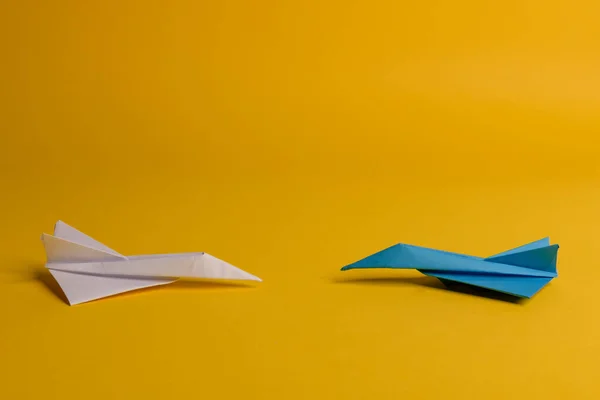 Grupo de plano de papel en una dirección y con un individuo apuntando de manera diferente sobre fondo amarillo. Línea punteada de cola de avión . — Foto de Stock