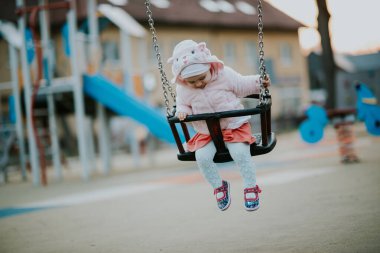 Küçük kız çocuk parkında harika vakit geçiriyor. Mutlu çocuk