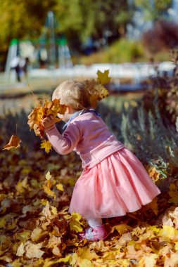 Sevimli kız güzel bir sonbahar gününde eğleniyor. Otantik resim