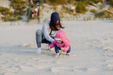 Anne ve küçük kızı sahilde eğleniyorlar. Özgün Li