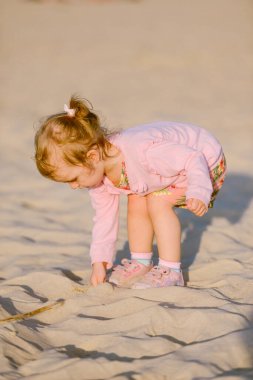 Güneşli bir kumsalda küçük sevimli bir kız. Özgün yaşam biçimi