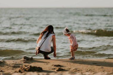 Anne ve küçük kızı sahilde eğleniyorlar. Özgün Li