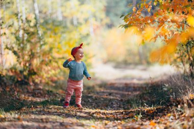 Sevimli kız güzel bir sonbahar gününde eğleniyor. Otantik resim