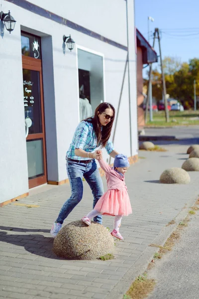 Mãe e filhinha estão andando e brincando no playgr — Fotografia de Stock