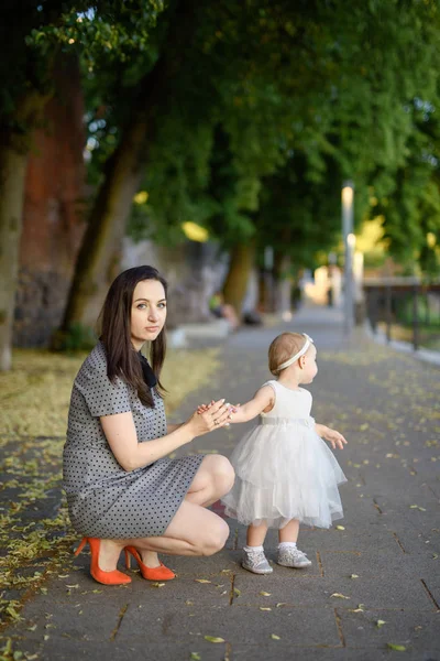 Happy mother and daughter in the park. Beauty nature scene with family outdoor lifestyle. Happy family resting together on the green grass, authentic lifestyle image. — Stock Photo, Image