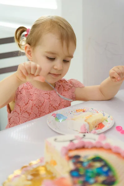 Baby meisje 1 jaar oud eten verjaardagstaart in de kamer. Verjaardagspartij. Kindertijd — Stockfoto
