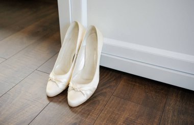 Gelin beyaz düğün ayakkabıları gösteriyor. Düğün ayrıntıları. Kapat..