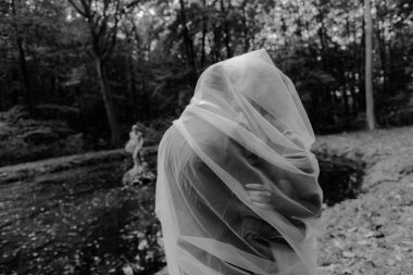 Gelin ve damat doğadaki bir fotoğraf çekiminde.