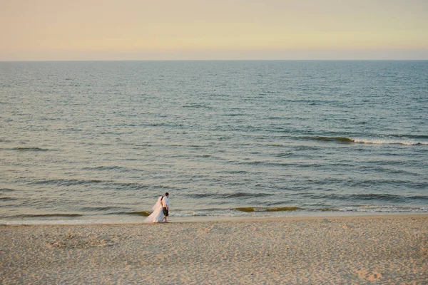 Bruid en bruidegom tijdens een fotosessie in de natuur. Oostzeestrand — Stockfoto