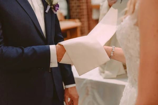 A noiva eo noivo durante a cerimônia de casamento colocar anéis de casamento em seus dedos — Fotografia de Stock