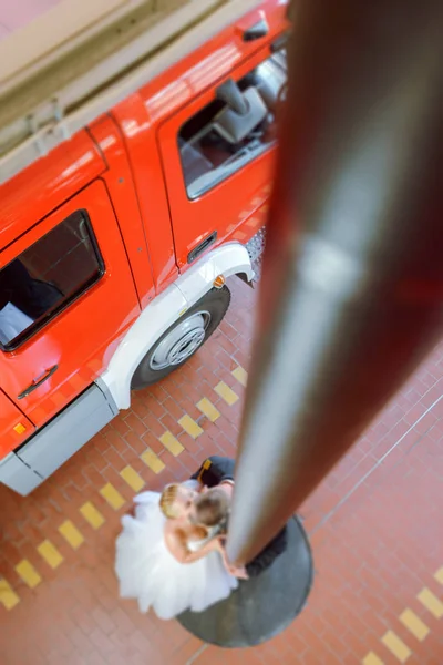 Beautiful wedding couple on outdoor photoshoot with fire truck. — Stock Photo, Image