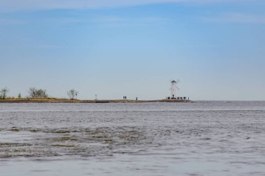 Swinoujscie 'deki eski deniz feneri, Polonya' da Baltık Denizi kıyısında bir liman. Deniz feneri geleneksel bir yel değirmeni olarak tasarlandı. Panoramik resim.