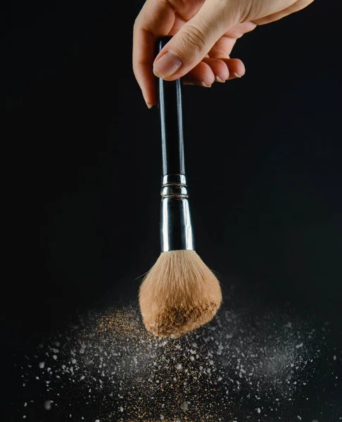 close up of a make up powder and a brush.