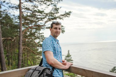 park ve gülümseyen ahşap merdivenlerde oturan adam