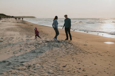 Mutlu anne, baba ve kızı parkta. Aile açık yaşam tarzı ile güzellik doğa sahnesi. Mutlu aile yeşil çimenler üzerinde birlikte dinleniyor, dışarıda eğleniyor. Ailede mutluluk ve uyum 