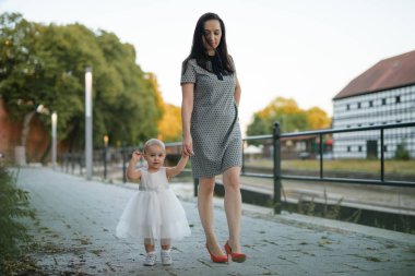 Parktaki mutlu anne ve kız. Aile hayatı olan güzel doğa manzarası. Mutlu bir aile yeşil çimlerin üzerinde birlikte dinleniyor, dışarıda eğleniyor. Aile hayatında mutluluk ve uyum.