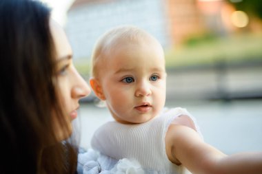 Parktaki mutlu anne ve kız. Aile hayatı olan güzel doğa manzarası. Mutlu bir aile yeşil çimlerin üzerinde birlikte dinleniyor, dışarıda eğleniyor. Aile hayatında mutluluk ve uyum.
