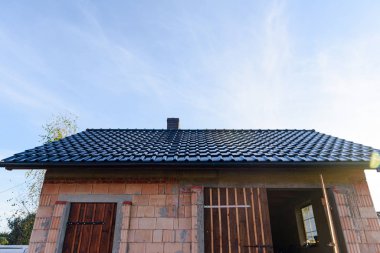 Yapım aşamasındaki, çatısı ve penceresi olan Tamamlanmamış Kırmızı Tuğla garajının dışı