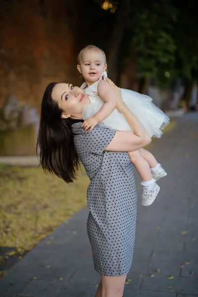 Madre e figlia felici nel parco. Scena di bellezza natura con stile di vita familiare all'aperto. Famiglia felice che riposa insieme sull'erba verde, divertendosi all'aperto. Felicità e armonia nella vita familiare — Foto Stock