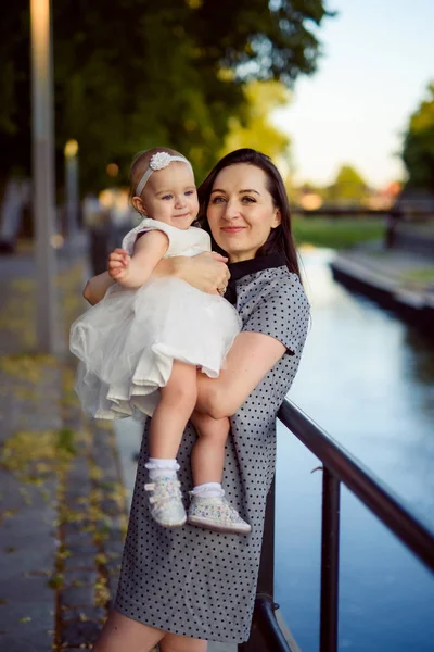 Madre e figlia felici nel parco. Scena di bellezza natura con stile di vita familiare all'aperto. Famiglia felice che riposa insieme sull'erba verde, divertendosi all'aperto. Felicità e armonia nella vita familiare — Foto Stock