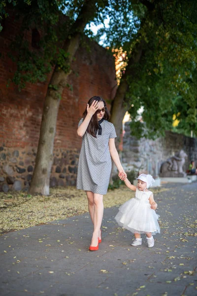 Happy mother and daughter in the park. Beauty nature scene with family outdoor lifestyle. Happy family resting together on the green grass, having fun outdoor. Happiness and harmony in family life — Stock Photo, Image