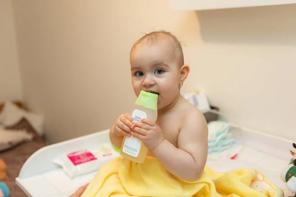 Adorable niña sentada bajo una toalla con capucha después del baño —  Fotos de Stock