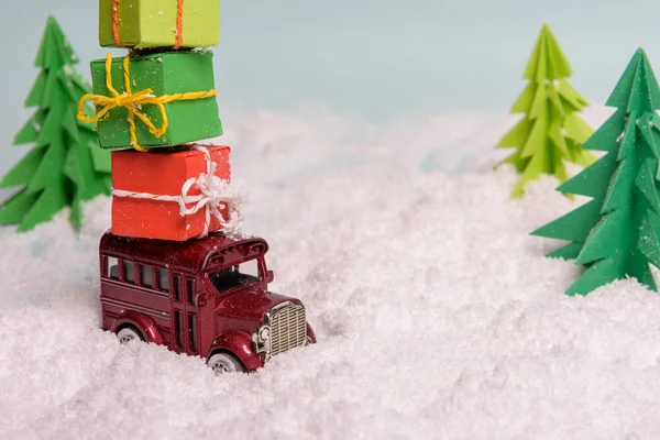 Une voiture porte des cadeaux sous le sapin de Noël à la neige. Vie. — Photo