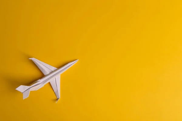 Ομάδα χάρτινων αεροπλάνων προς μία κατεύθυνση και με ένα άτομο να δείχνει με διαφορετικό τρόπο σε κίτρινο φόντο. Αιωρούμενη γραμμή από ουρά αεροσκάφους. — Φωτογραφία Αρχείου