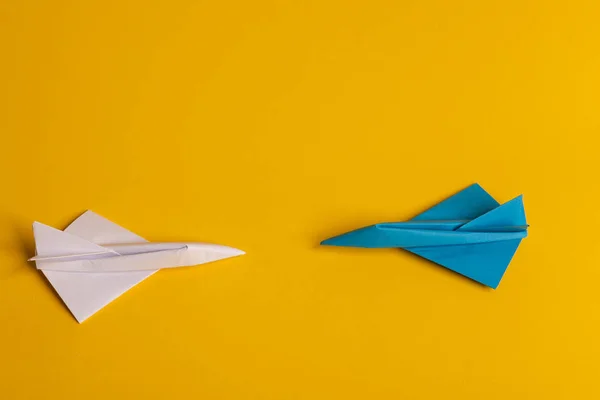 Grupo de plano de papel en una dirección y con un individuo apuntando de manera diferente sobre fondo amarillo. Línea punteada de cola de avión . — Foto de Stock