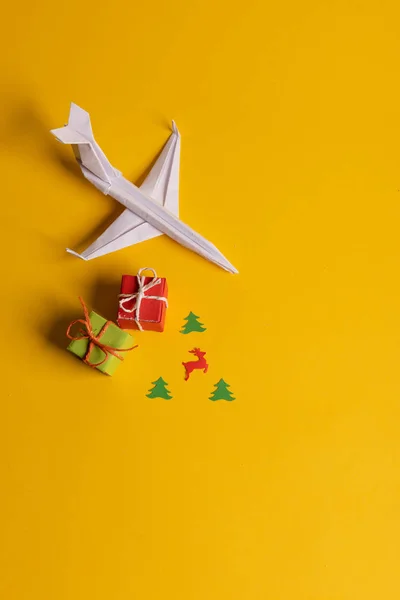 Grupo de plano de papel en una dirección y con un individuo apuntando de manera diferente sobre fondo amarillo. Viaje de Navidad. Regalos y regalos. —  Fotos de Stock