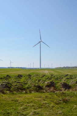 Parlak mavi gökyüzü hareket ediyor ve rüzgar türbini