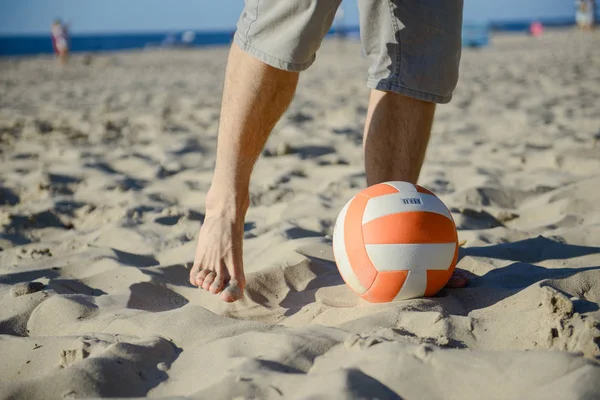 Чоловік грає у футбол на пляжі Ліцензійні Стокові Зображення