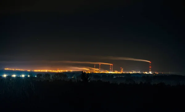 Parc industriel la nuit, grande cheminée avec fumée. Police Pologne — Photo