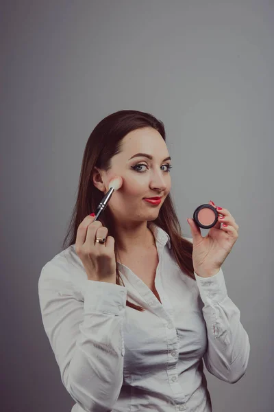 Mujer sosteniendo un conjunto de cepillos cosméticos para el maquillaje , — Foto de Stock