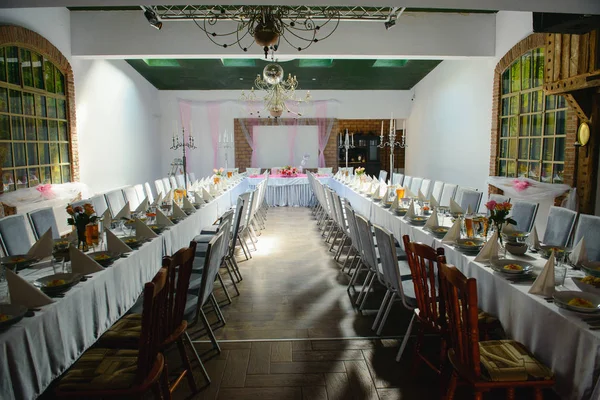 Красиво оформленный свадебный стол и другие детали в свадебном зале. День свадьбы. — стоковое фото