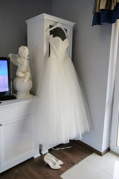 Koszorúslány segít karcsú menyasszony lacing neki esküvő fehér ruha, — Stock Fotó