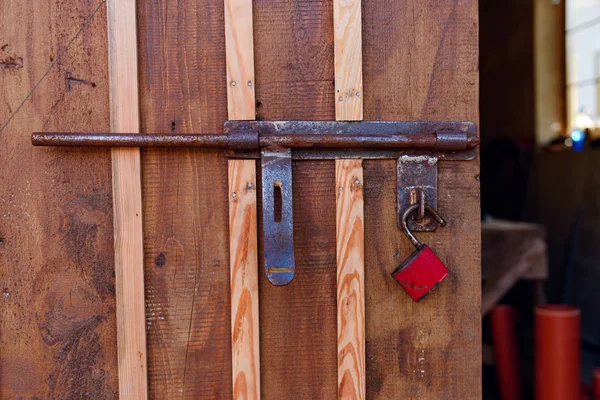 Antiguo candado rojo en una puerta de madera . —  Fotos de Stock