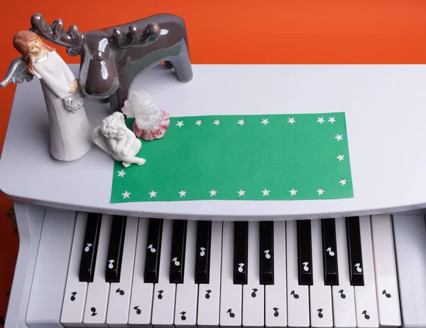 Белое игрушечное пианино с бумажными нотами. музыкальное фортепиано. вид сверху — стоковое фото