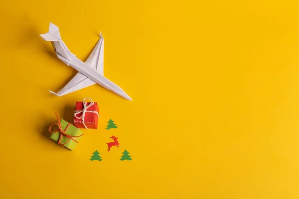 Tek yönlü kağıt uçak grubu ve sarı arka planda farklı yönleri gösteren tek bir kişi. Noel şakası. Hediyeler ve hediyeler. — Stok fotoğraf