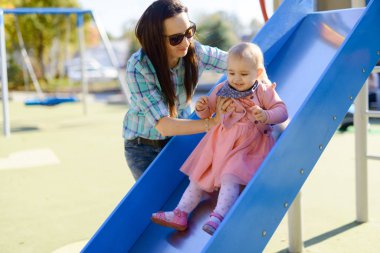 Parktaki mutlu anne ve kız. Aile hayatı olan güzel doğa manzarası. Mutlu bir aile yeşil çimlerin üzerinde birlikte dinleniyor, dışarıda eğleniyor. Aile hayatında mutluluk ve uyum.