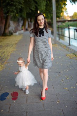 Parktaki mutlu anne ve kız. Aile hayatı olan güzel doğa manzarası. Mutlu bir aile yeşil çimlerin üzerinde birlikte dinleniyor, dışarıda eğleniyor. Aile hayatında mutluluk ve uyum.