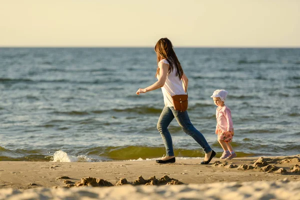 Moeder en dochtertje spelen op het strand. Authentiek beeld — Stockfoto