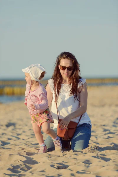 Mãe e filha brincando na praia. Imagem autêntica — Fotografia de Stock