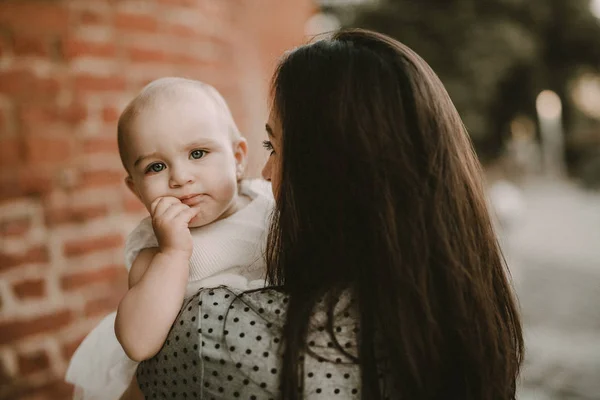 Mãe e filha felizes no parque. Cena da natureza da beleza com estilo de vida familiar ao ar livre. Família feliz descansando juntos na grama verde, se divertindo ao ar livre. Felicidade e harmonia na vida familiar — Fotografia de Stock