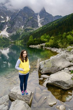 Kadın gölde ve dağlarda dinleniyor güneşli manzara